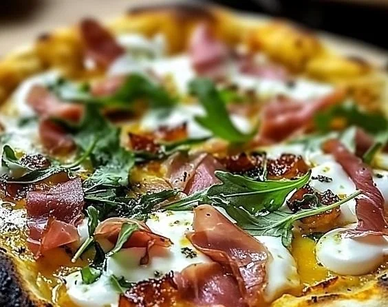 Gourmet prosciutto pizza topped with honey and fresh arugula on a wooden board