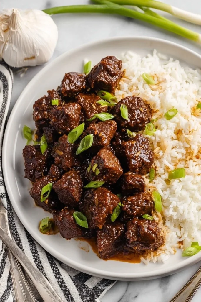 Honey garlic steak bites served on a plate, showcasing a savory dish.