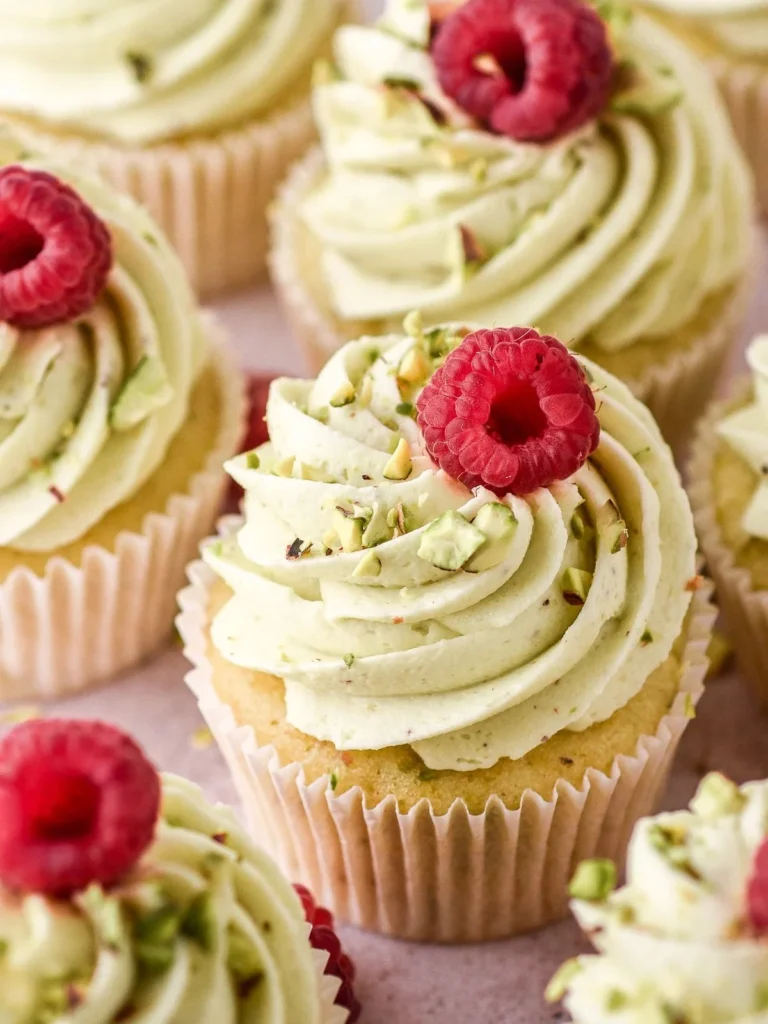 Delicious pistachio cupcakes topped with creamy frosting and sprinkled nuts