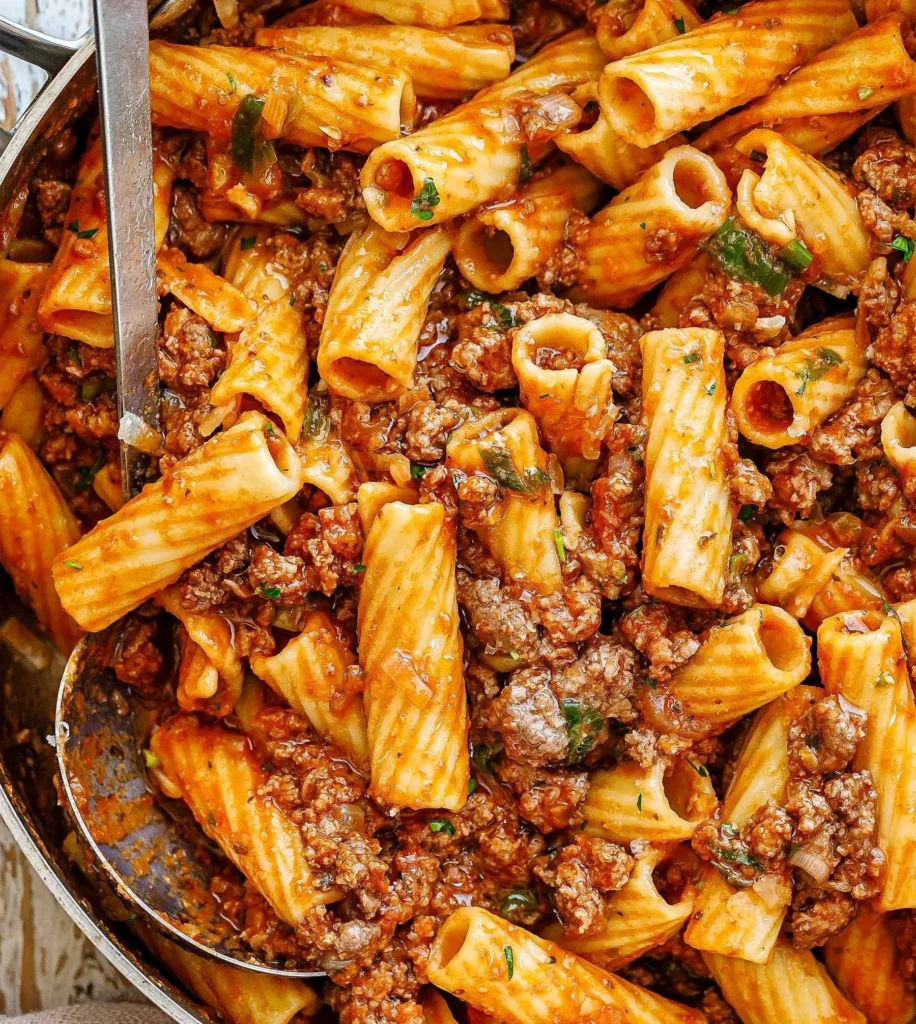 Beef Pasta in Tomato Sauce served on a plate, topped with fresh herbs