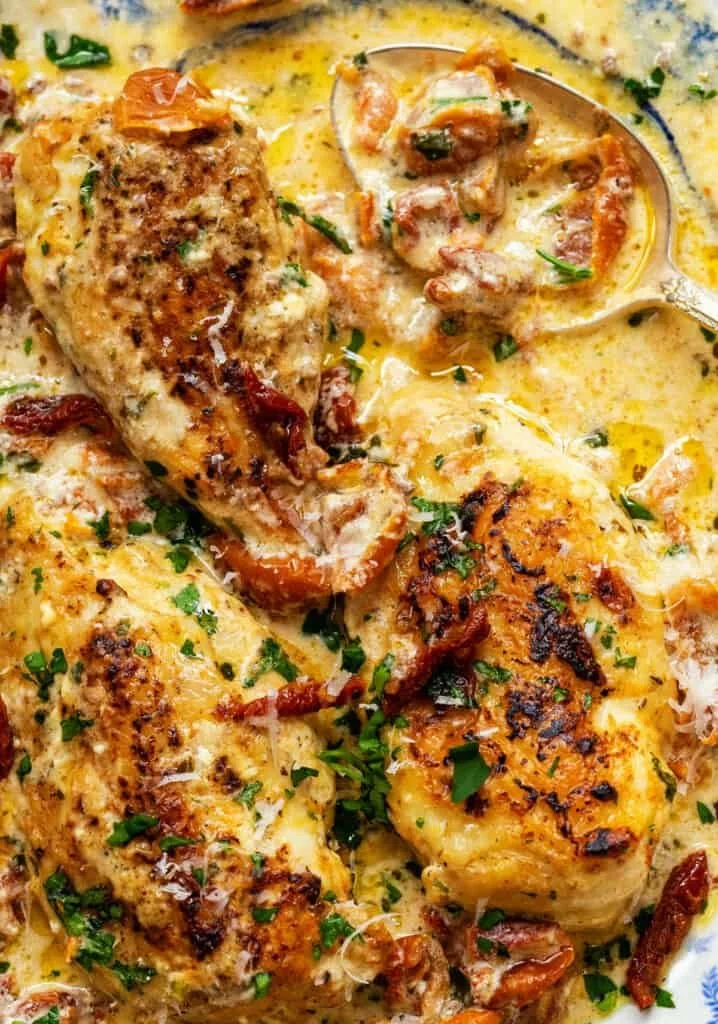 Crock Pot Marry Me Chicken served with herbs and creamy sauce on a plate.