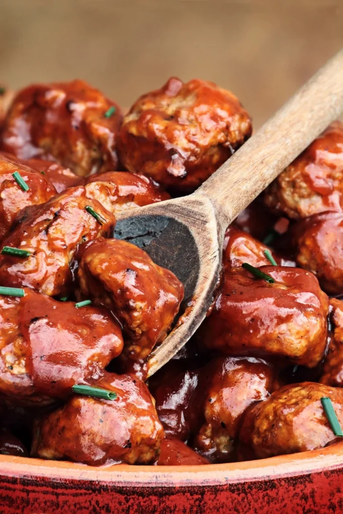 A plate of healthy apple cider turkey meatballs garnished with fresh herbs.