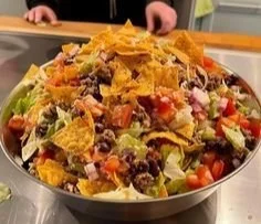 A colorful bowl of easy Doritos Taco Salad with vibrant vegetables and crunchy chips