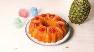 Pineapple Upside Down Bundt Cake decorated with pineapple slices and cherries