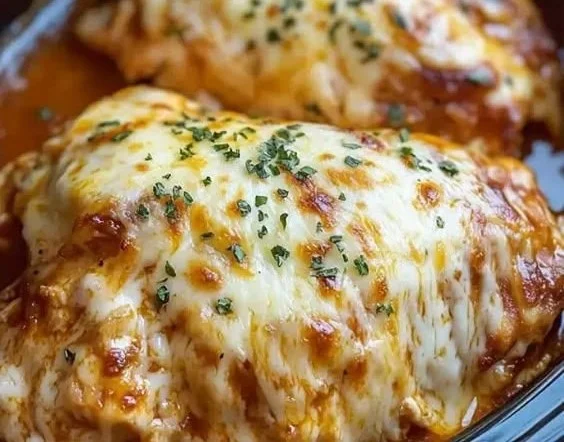 Slow cooker cheesy mozzarella chicken topped with melted cheese and herbs