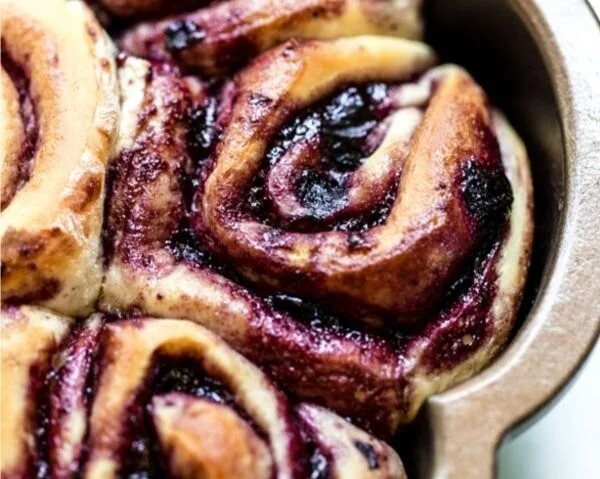 Soft cinnamon rolls topped with blueberries, fresh from the oven.