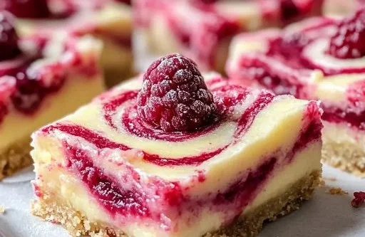 Delicious lemon raspberry swirl bars served on a plate with fresh berries.