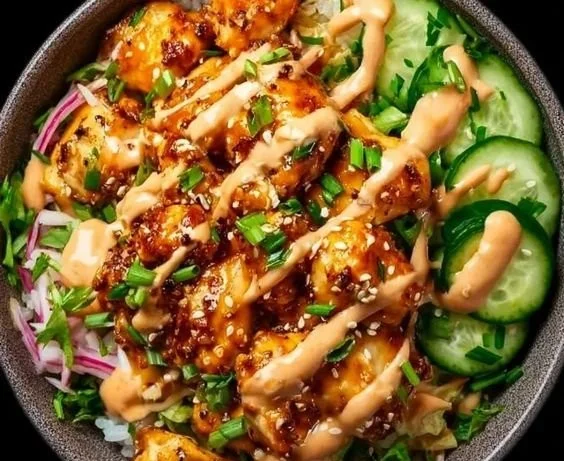 Delicious Bang Bang Chicken Bowl served with fresh vegetables and creamy sauce.