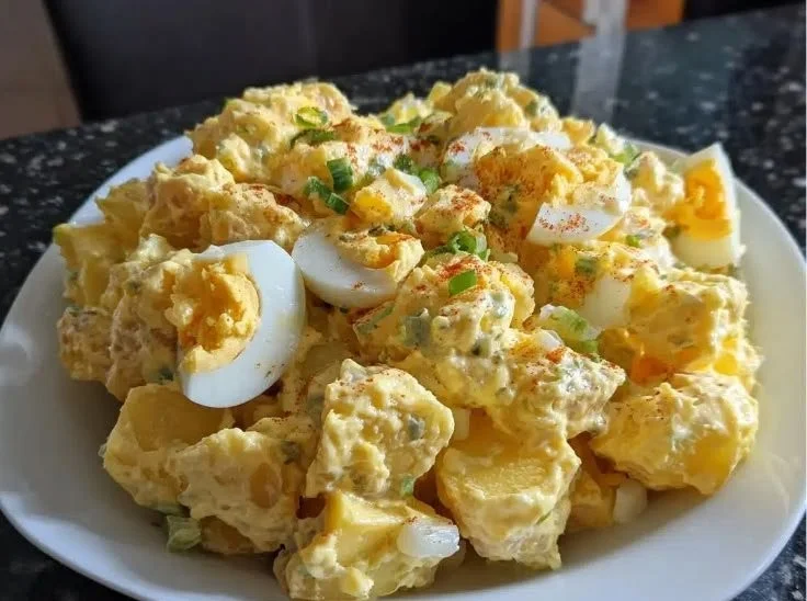 Bowl of classic potato salad with herbs and vegetables