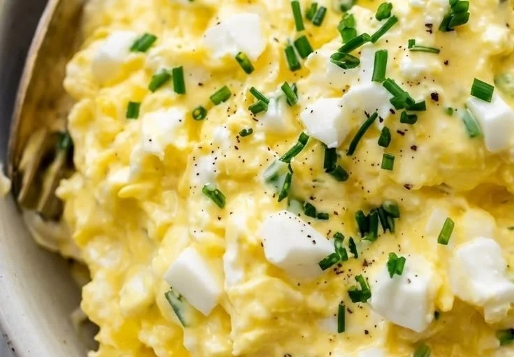 A bowl of Cottage Cheese Egg Salad garnished with herbs and served with crackers.