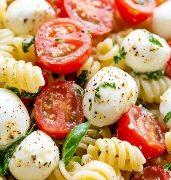 Delicious creamy Caprese pasta salad with tomatoes, mozzarella, and basil