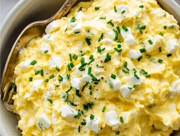 Creamy cottage cheese egg salad served in a bowl with fresh herbs.