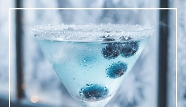 Frostbite-Inspired Blueberry Martini garnished with fresh blueberries.