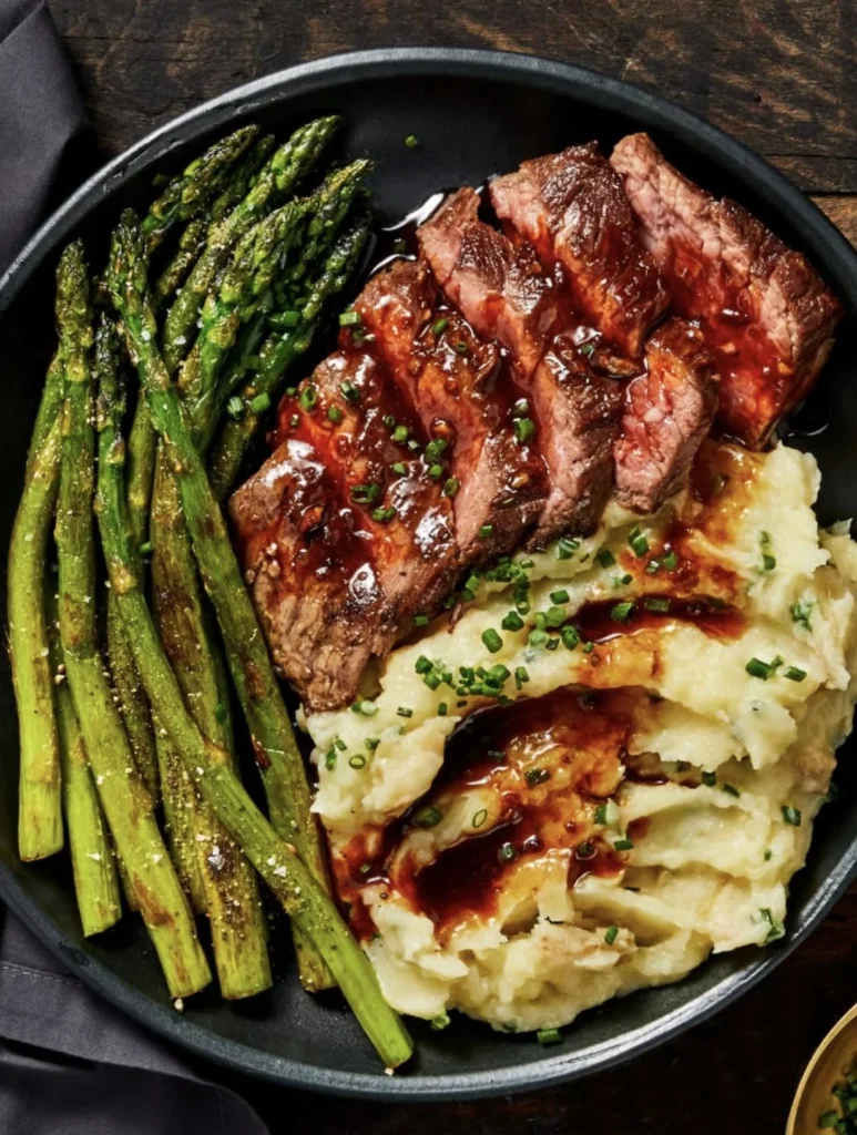 Delicious Garlic Butter Steak with creamy mashed potatoes and roasted asparagus