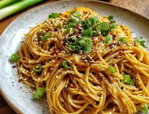 Plate of Garlic Sesame Noodles garnished with sesame seeds and green onions