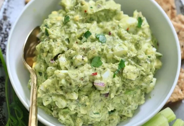 Bowl of herby avocado egg salad with fresh herbs and ingredients