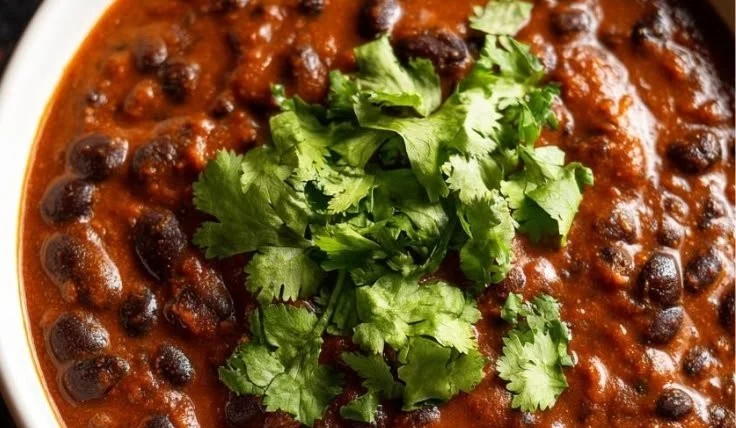 Bowl of Minute Black Bean Soup served with fresh herbs and toppings