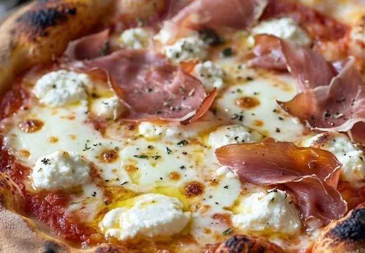 Delicious homemade prosciutto white pizza topped with creamy cheese and herbs.