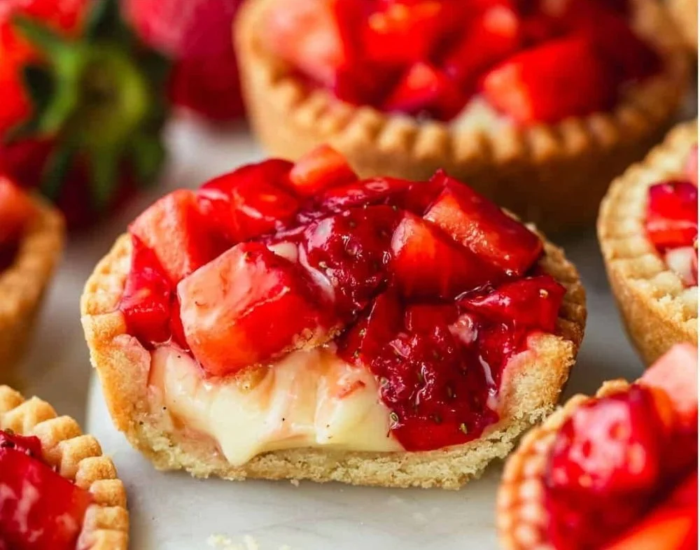 Quick mini strawberry custard tarts on a plate with fresh strawberries