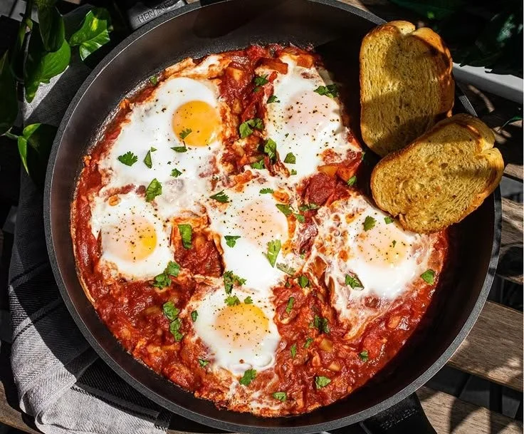 Delicious shakshuka with poached eggs in rich tomato sauce