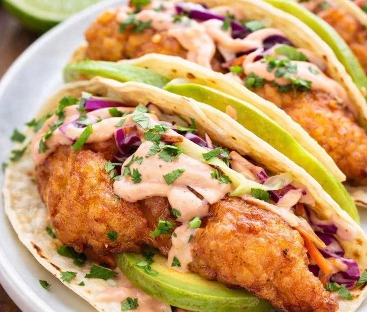 Crispy fish tacos with avocado served on a plate