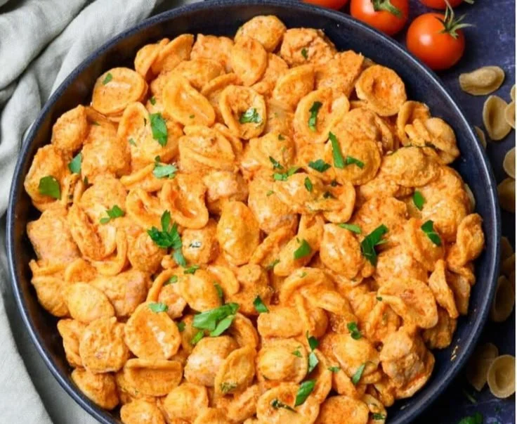 Bowl of creamy cottage cheese pasta sauce with herbs and pasta.