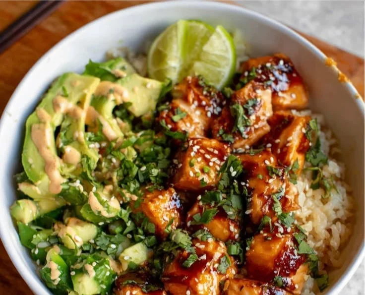 Honey glazed salmon rice bowl topped with colorful vegetables and sesame seeds