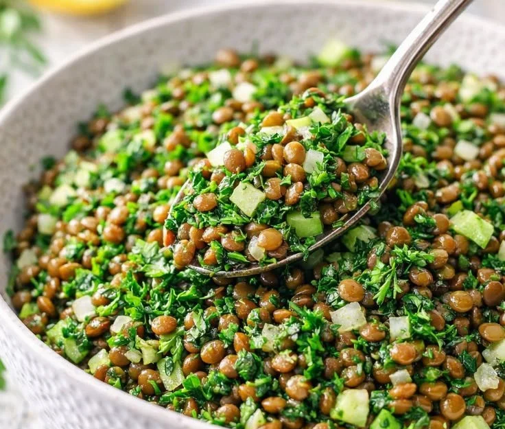 Bowl of Lebanese Lentil Salad garnished with fresh vegetables and herbs
