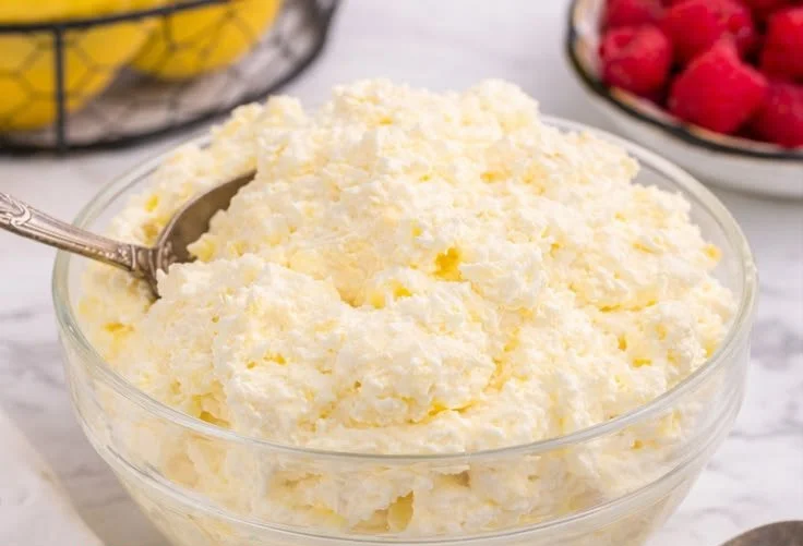 Delicious Lemon Fluff dessert served in a bowl with a lemon slice garnish.