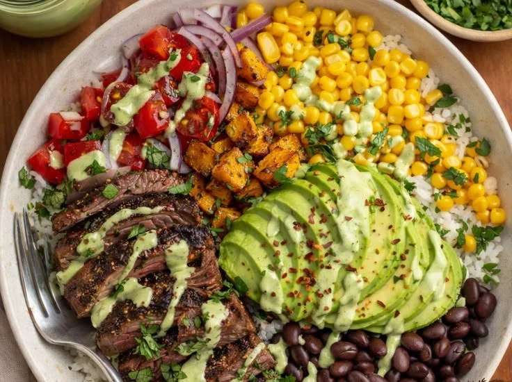 Steak and avocado bowl topped with cilantro cream sauce for a healthy meal