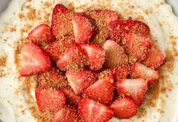 Delicious strawberry cheesecake yogurt bowl topped with fresh strawberries and granola