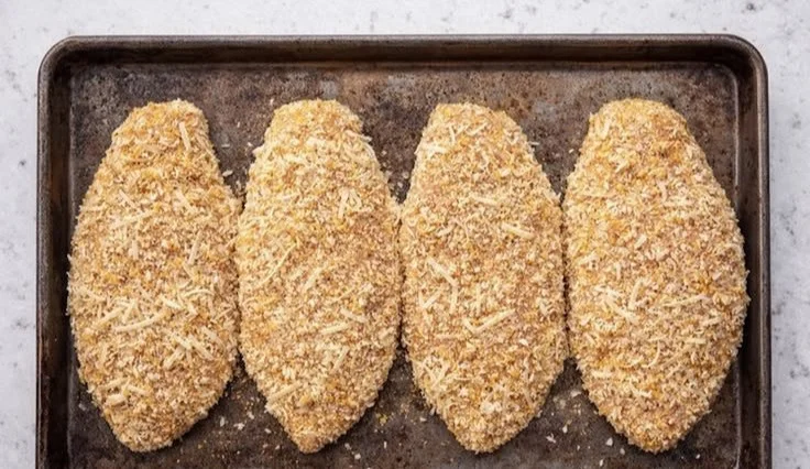 Baked chicken breasts served with vegetables and herbs on a plate