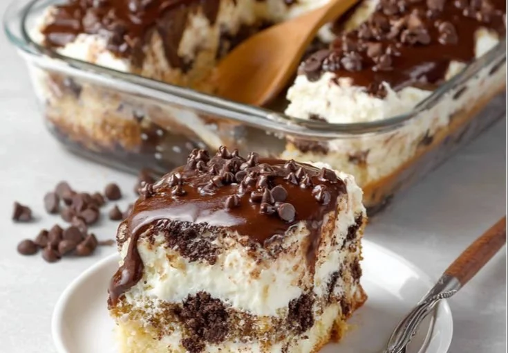 Delicious cannoli cake topped with cream and chocolate chips, a perfect dessert choice.