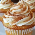 Delicious cinnamon roll cupcake topped with icing and cinnamon sugar.