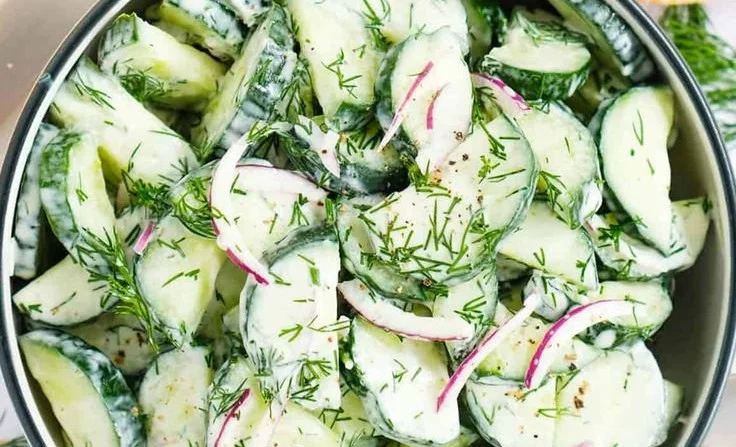 Fresh cucumber dill salad served in a bowl with herbs