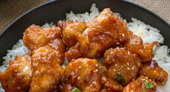 Delicious General Tsos Chicken served with rice and vegetables, homemade recipe