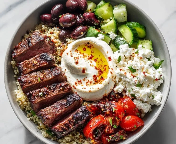 Mediterranean steak bowl with fresh vegetables and herbs