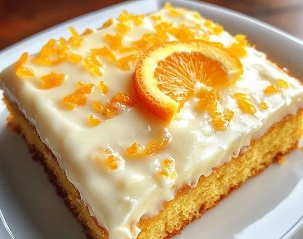 Moist orange sheet cake topped with fresh orange slices and icing