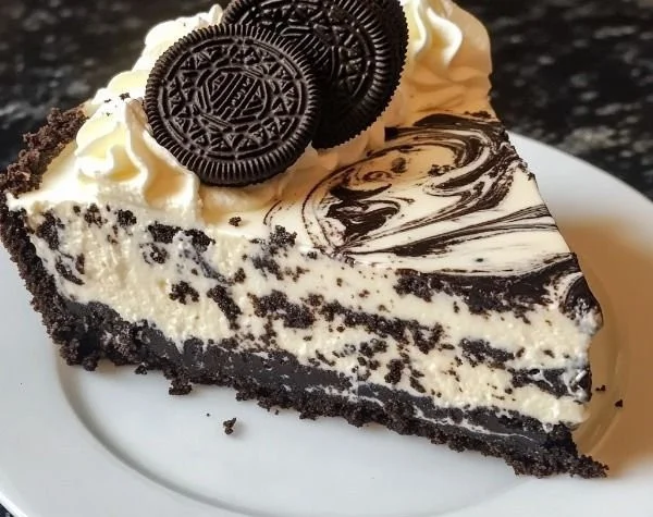 Delicious Oreo cheesecake topped with crushed Oreos and whipped cream