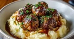 Salisbury steak meatballs served with garlic herb mashed potatoes on a plate