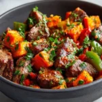 Savory steak bites served with sweet potatoes and colorful peppers on a plate